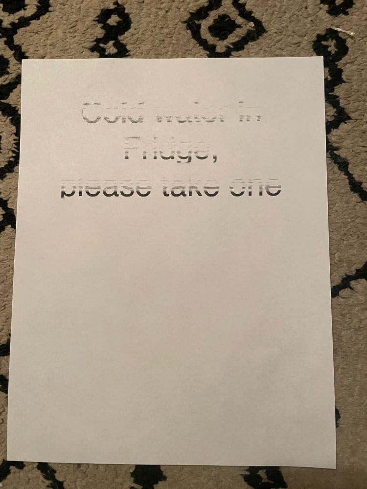 A poorly printed sign that you can barely read a saying “cold water and fridge, please take one” looks like vapor art.