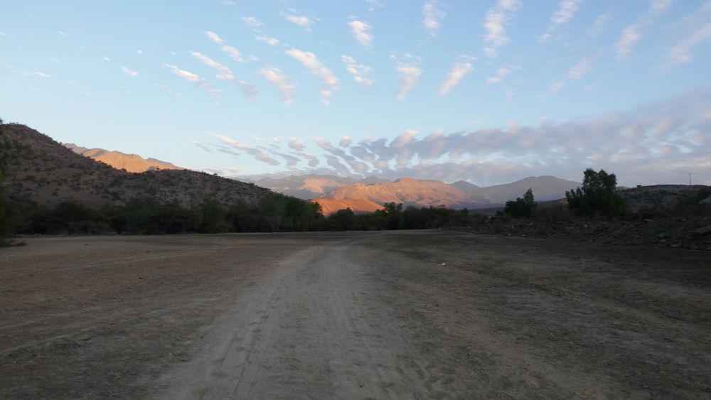 Vista de un paisaje con montañas y algunas nubes.