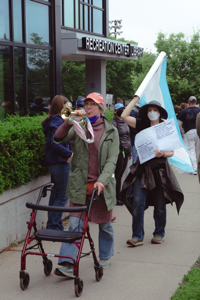 Woman with walker and trumpet marching