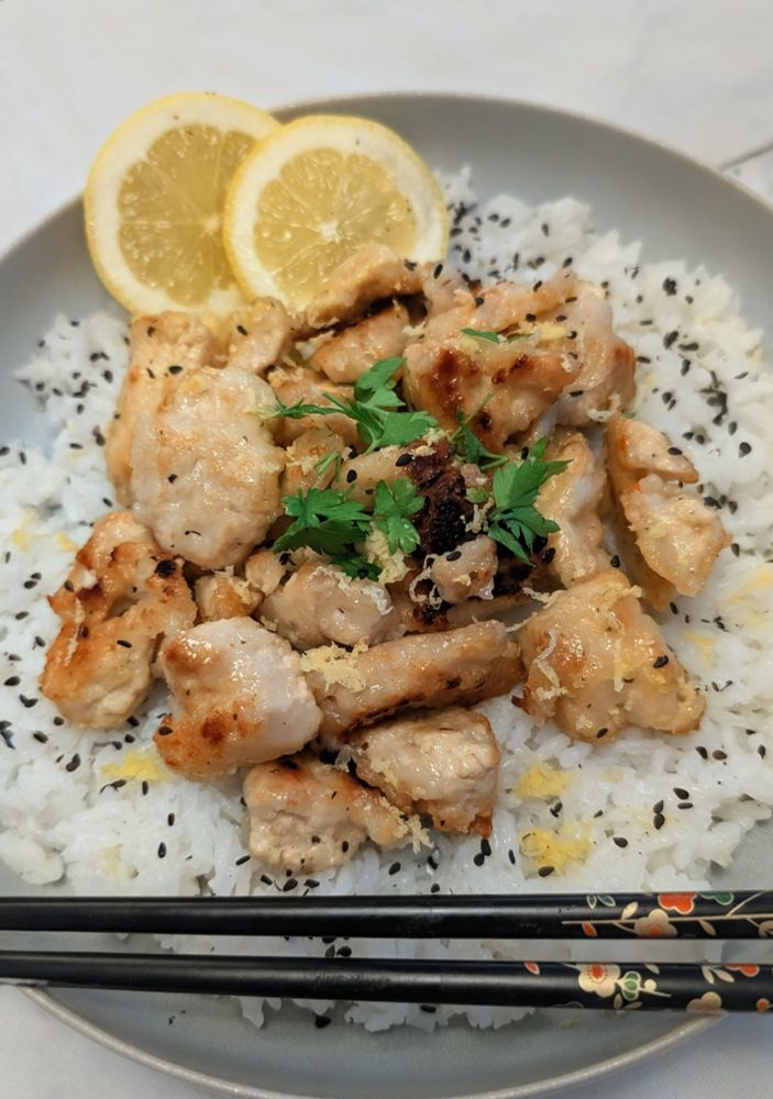 Zitronentofu auf Reis, garniert mit schwarzem Sesam.