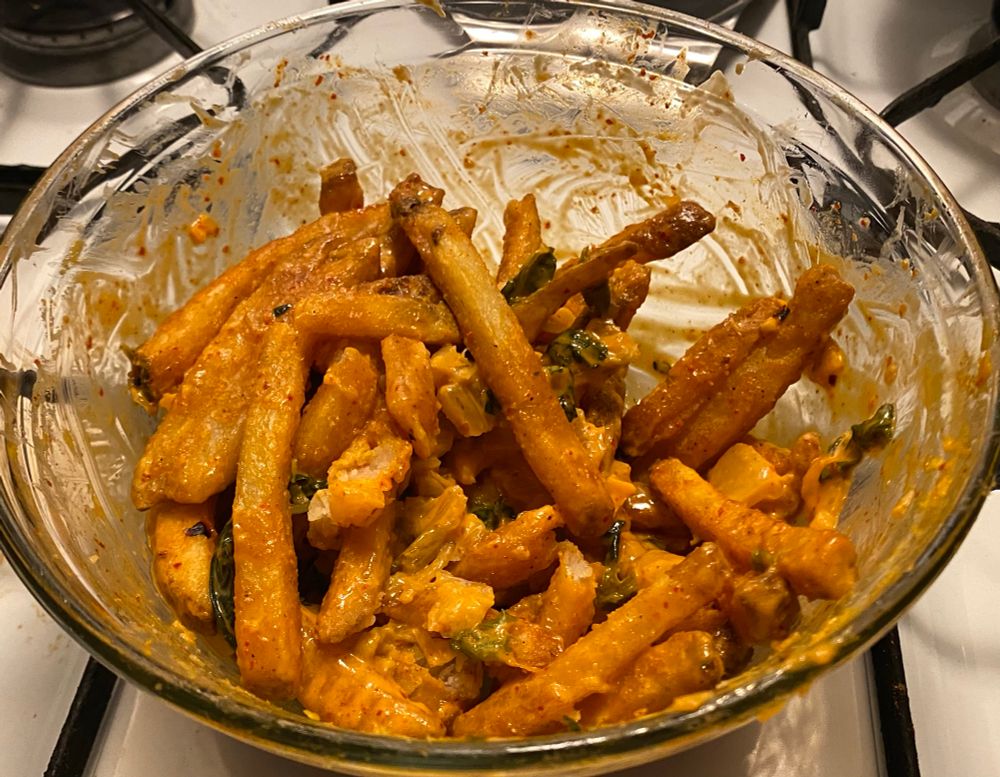 a bowl of french fries covered in kimchi & merkts chedder