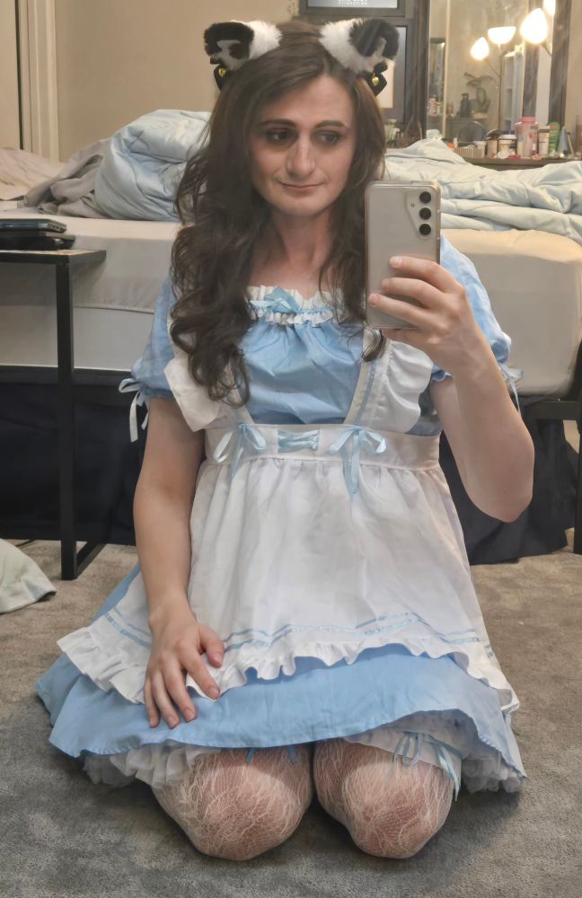 Ashes in a blue maid dress with white apron and cat ears headband sitting on her knees