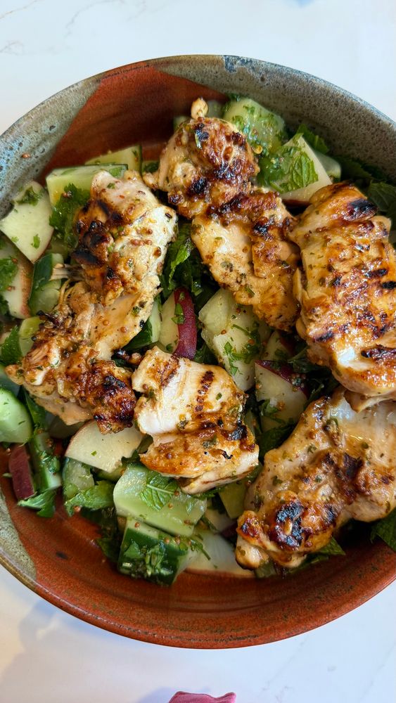 Grilled chicken in a whole grain mustard, chilli, and coriander marinade on a salad of squished cucumber and peach slices. 