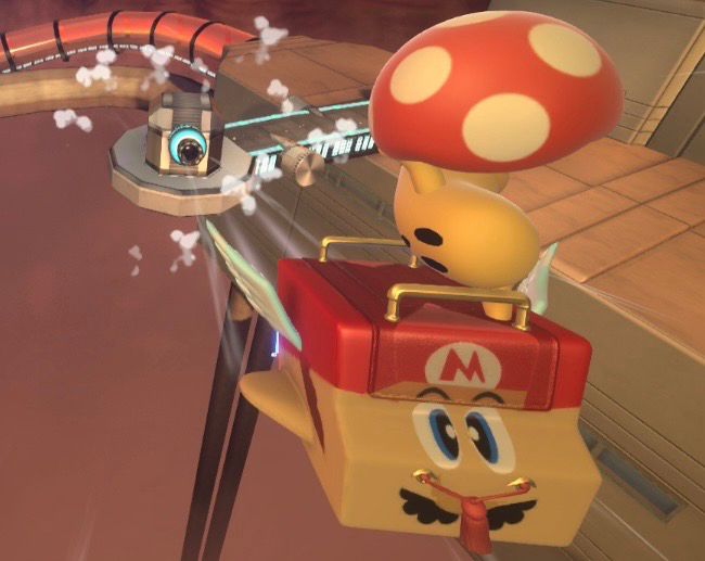 Kirby Air Riders screenshot: Cappy riding a a Wagon Star decorated to look like SM64 Wing Mario, shooting out of the cannon on Machine Passage