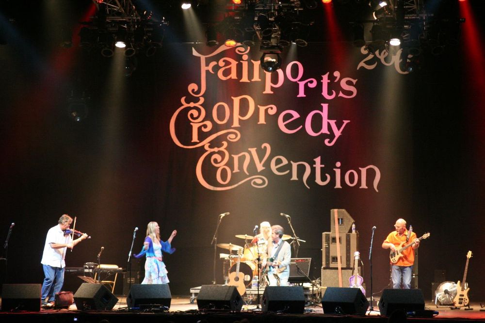 Stage with backdrop saying 'Fairport's Cropredy Convention' in Fairport conventions' signature cursive font. (Wikimedia commons)