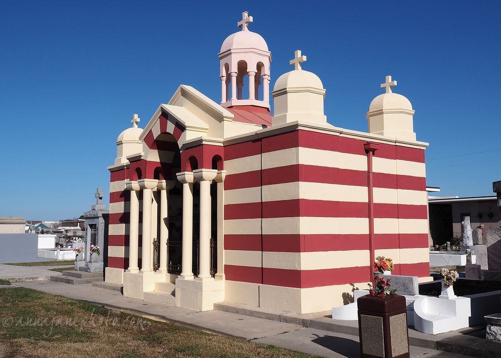 A large red and cream striped mausoleum in the style of a Greek Orthodox temple. 