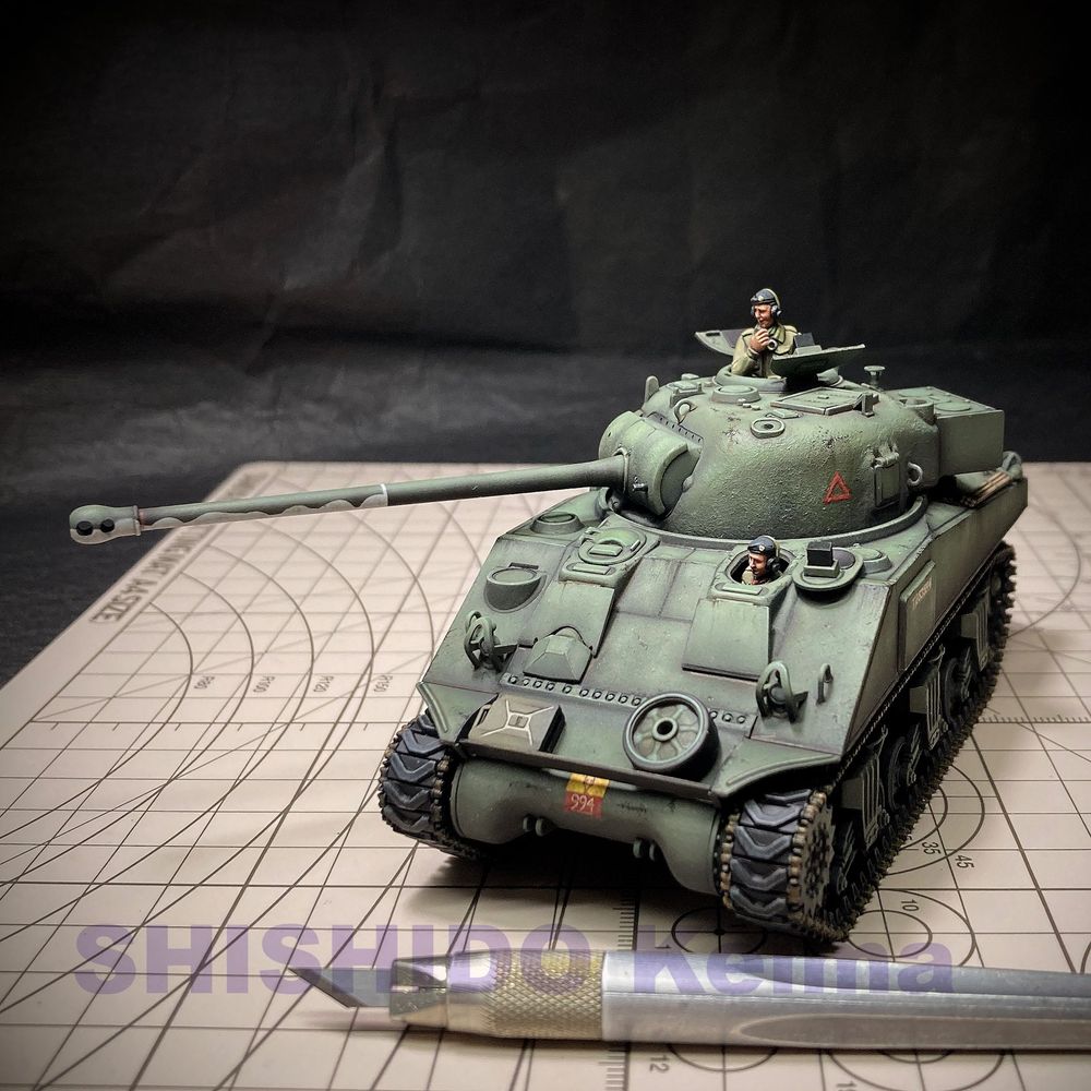 イギリス軍シャーマン ファイアフライ戦車、タミヤ1/48スケール。緑の塗装。前方やや左から。ハッチから搭乗員が顔を出している。