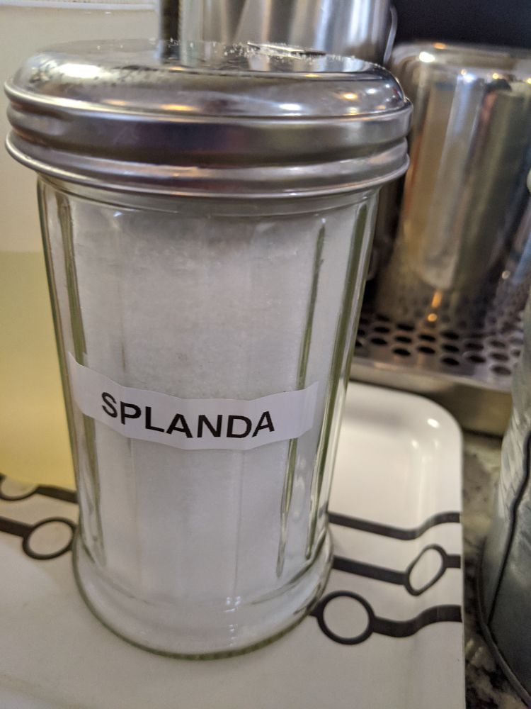 Splenda dispenser at a coffee shop is labeled 