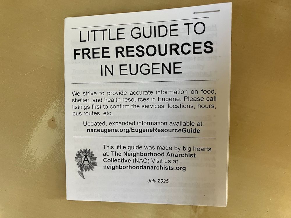Photo of the little guide on a wood table. The guide is two pieces of paper folded into a small square. Text on the paper reads: 

LITTLE GUIDE TO FREE RESOURCES IN EUGENE
We strive to provide accurate information on food, shelter, and health resources in Eugene. Please call listings first to confirm the services, locations, hours, bus routes, etc.

Updated, expanded information available at:
naceugene.org/EugeneResourceGuide

This little guide was made by big hearts at: The Neighborhood Anarchist
Collective (NAC) Visit us at: neighborhoodanarchists.org

July 2025