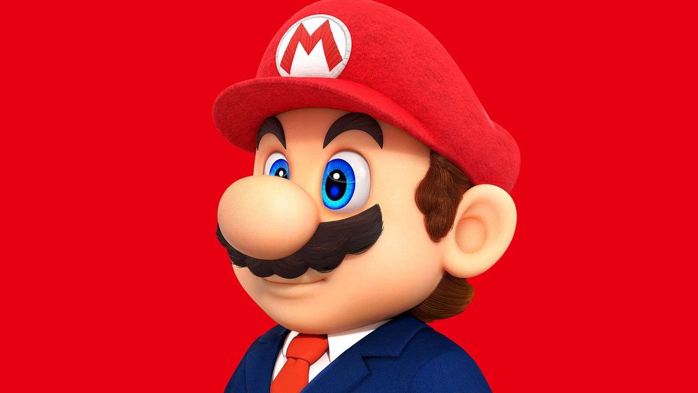Mario en costume d'affaire avec une cravate rouge.