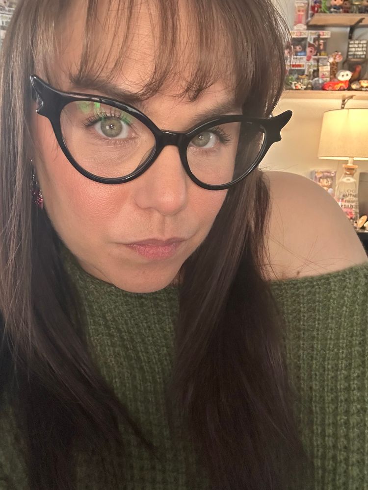 Woman with glasses wearing a green sweater