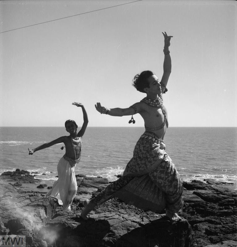 📷 Cecil Beaton (reversed)
Black & white photograph of Ram Gopal and another dancer, dancing on a rock platform by the sea, their arms waving as they stride to our right. In almost parallel sections we see sky, sea and rock as the background to their curved lyrical figures.