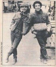 📷 'Steve Wright' (probably Stephen Wright)

Photograph as it appears in an article of a magazine of Marcel King (right) leaning against Jim(?) Crawford. Shoulder to shoulder they keep each other from falling. Hands in pockets both have their inside leg crossing to the outside of their other leg, all nonchalant-like. Background is an open pavemented space, people can just be made out top and right, one sitting.