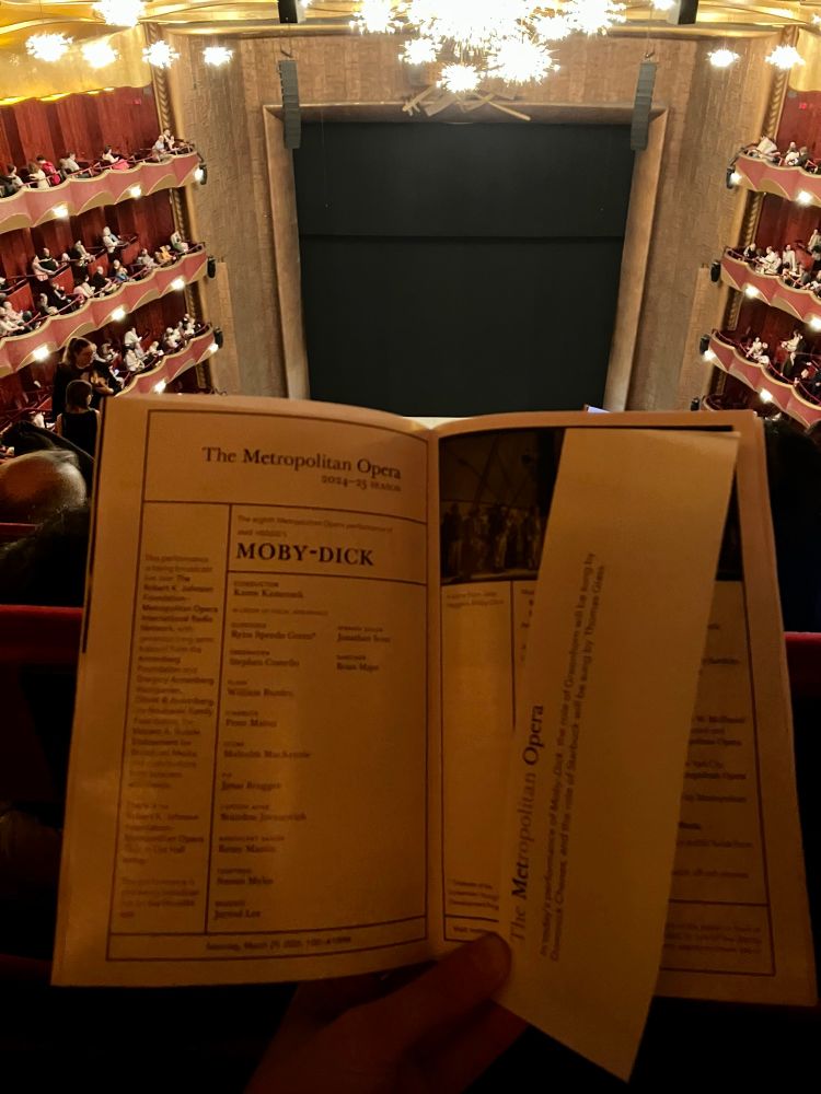 Inside the Metropolitan Opera house, with the stage in the background and a program for Moby-Dick (by Jake Heggie and Gene Scheer) in the foreground.