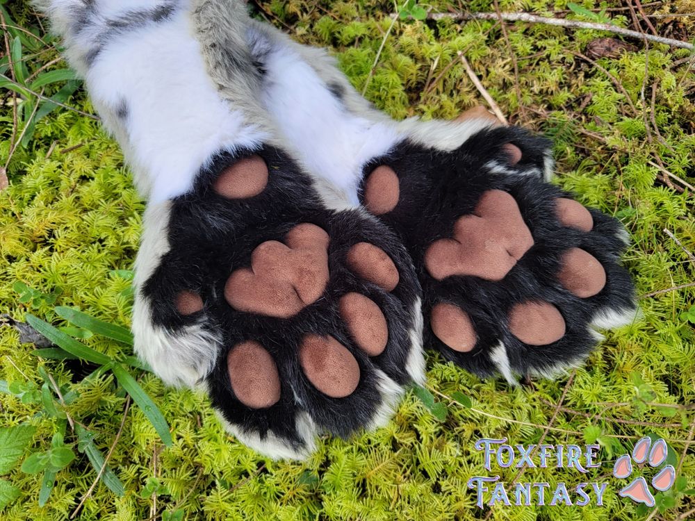 Slim Feline handpaws modeled on a bed of green moss 