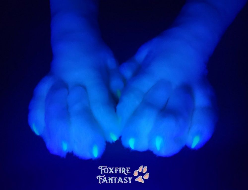 Uv photo of white feline handpaws on black 