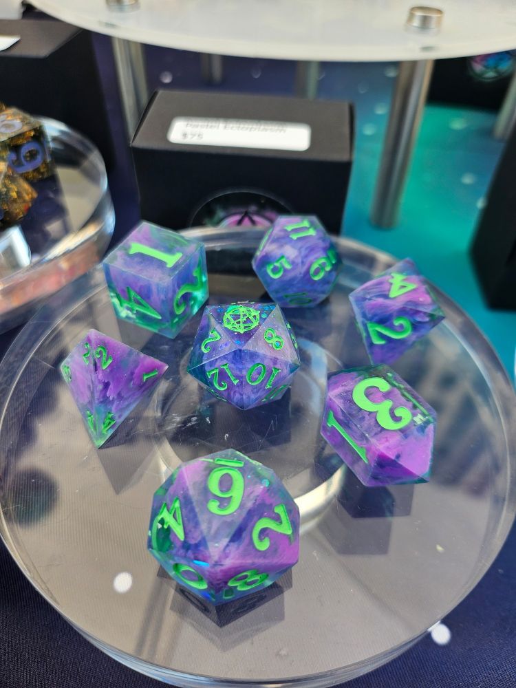 A set of polyhedral dice, swirls of purple in blue with bright green numbers named Pastel Ectoplasm