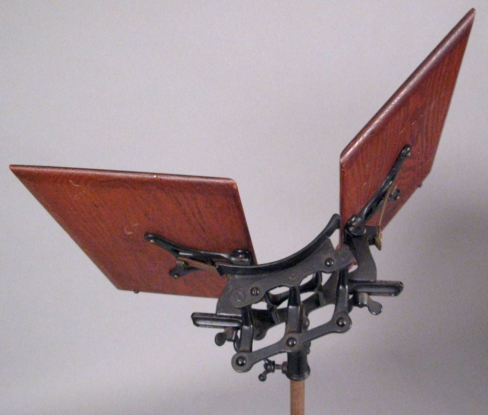a book stand that shows the adjustable gears that hold the rests meant for the fornt and back cover of the book 