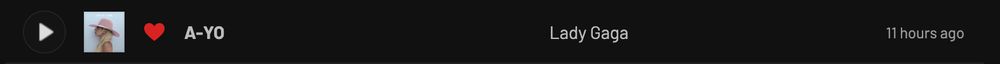 Screenshot of a music player interface showing a play button, album art of Lady Gaga wearing a pink hat, a red heart, the song title "A-YO", the artist "Lady Gaga", and the timestamp "11 hours ago".