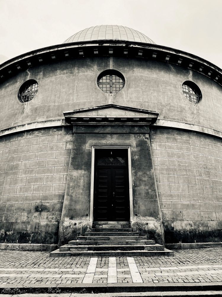A Neoclassical doorway of a round section of a building, with circular windows and a dome. The apse of Vor Frue Kirke (Church of Our Lady), Frue Plads, Copenhagen, Denmark. Photo by Gearóid Burke. 