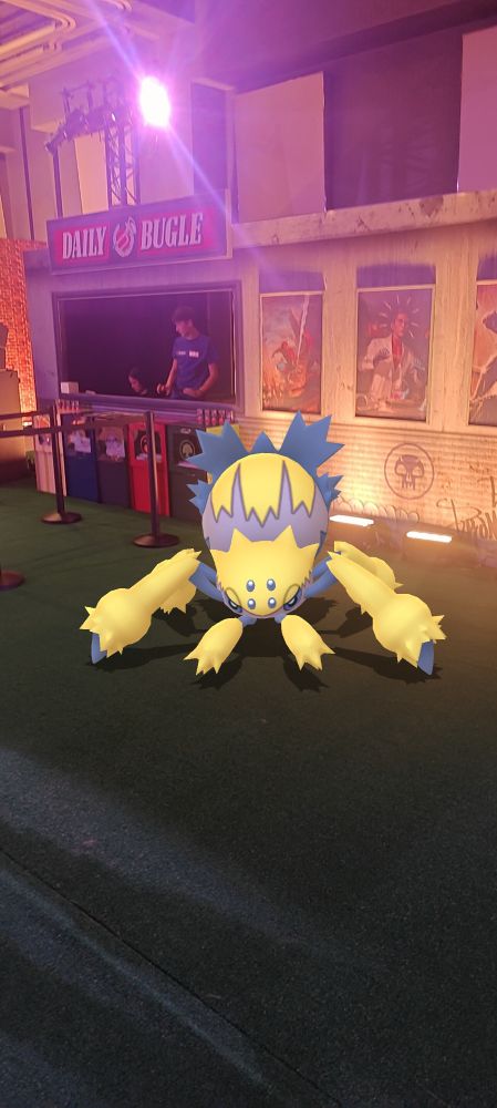 A Galvantula, a tarantula Pokemon, in front of a newspaper stand for the Daily Bugle.