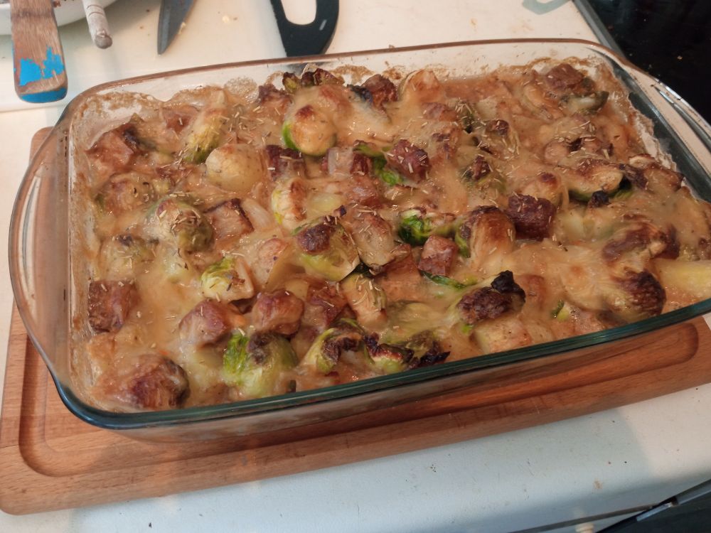 Auflaufform auf Arbeitsfläche. In der Auflaufform ist ein Rosenkohl-kartoffel-tofu auflauf.