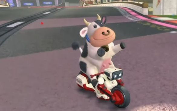 A cow driving a motorcycle on an empty road