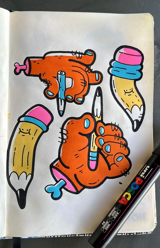 desenho no caderninho, na imagem duas mãos laranjas segurando lápis e dois lápis amarelos 