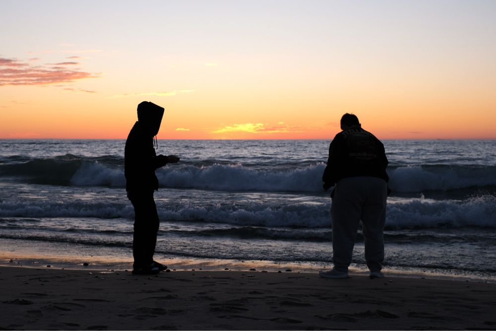 Siblings skipping rocks on Lake Michigan, in Grand Marais, Michigan