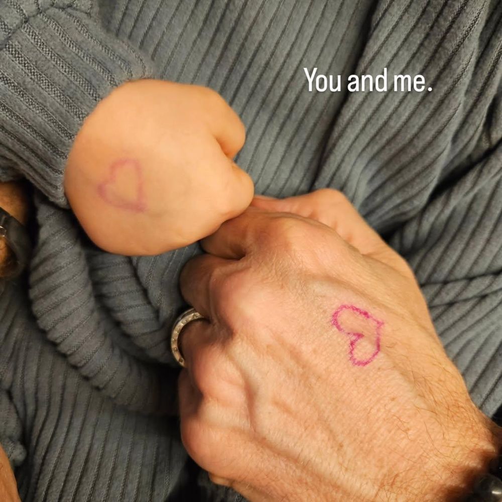 Die Faust meiner Tochter und meine Faust berühren sich. 

Beide haben ein gemalten Herz auf dem Handrücken. 
