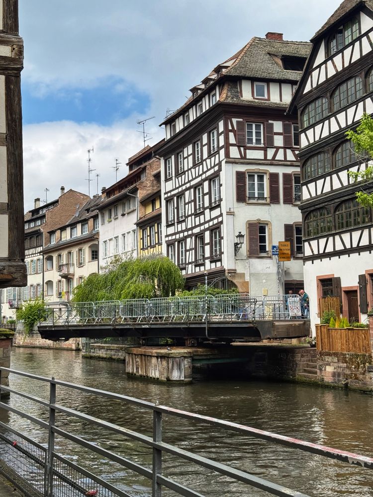 A Strasbourg canal lined with half-timbered houses and a swing bridge half open