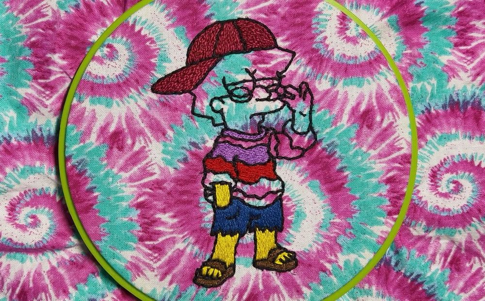 Embroidery of cool Lisa Simpson on a pink, blue, and white tie dye fabric 
