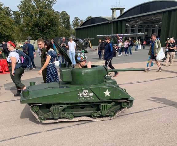 A man in a small tank at an airshow 