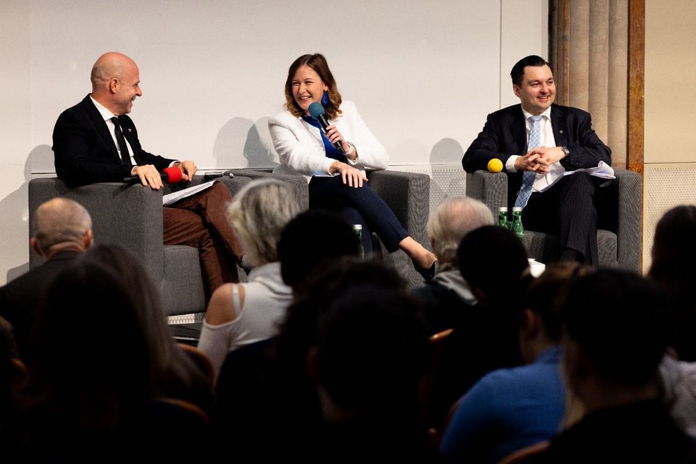 a group of people sitting in chairs and talking