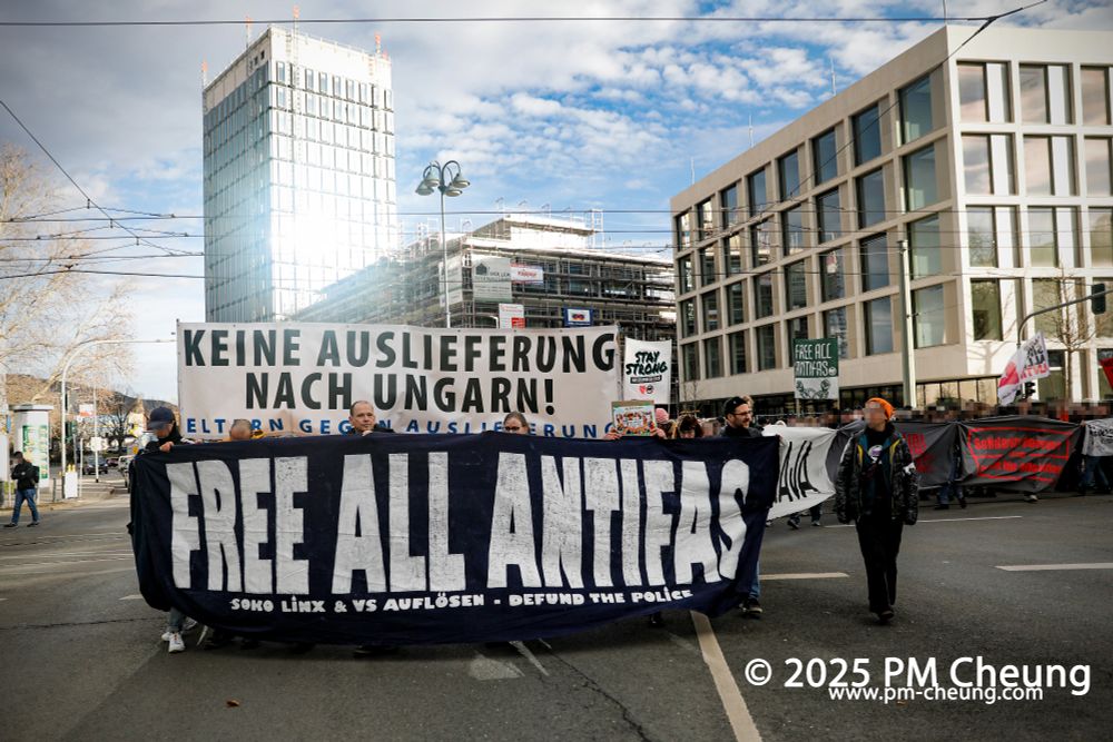 Die Demonstrationsspitze biegt in den Löbdergraben ein. Zu sehen ist neben dem Demonstrationszug außerdem ein Banner mit der Aufschrift "Free all antifas. Soko Linx & VS auflösen. Defund the Police" und ein weiteres mit der Aufschrift "Keine Auslieferung nach Ungarn!"-
