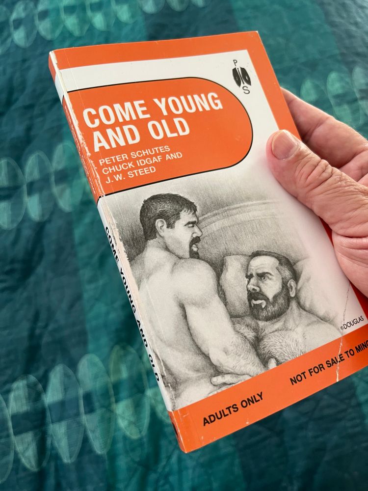 The author clutching an advance reader’s copy of “Come Young and Old” - Age Gap Erotica. A super sexy drawing by Pipeman Doug graces the cover.