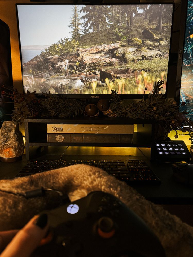 A still of Bramble: The Mountain King is on a computer monitor with yellow and orange backlights behind. 