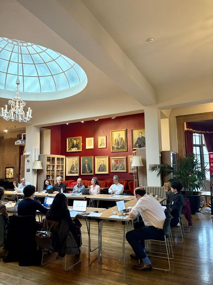 People sat around a table in a grand room 