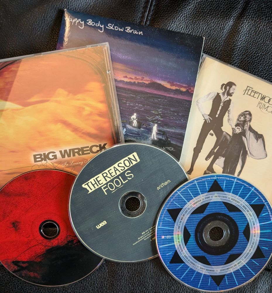 A spread of 3 cased CDs and 3 loose CDs.
1. Big Wreck - In Loving Memory Of...
2. Happy Body Slow Brain - Dreams of Water
3. Fleetwood Mac - Rumours
4. Death Cab for Cutie - Transatlanticism 
5. The Reason - Fools
6. Smashing Pumpkins - Zeitgeist 
