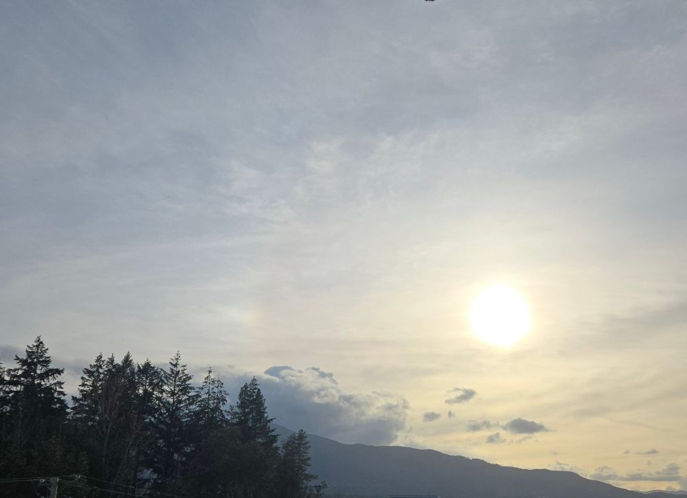 The evening sun setting behind a mountain 