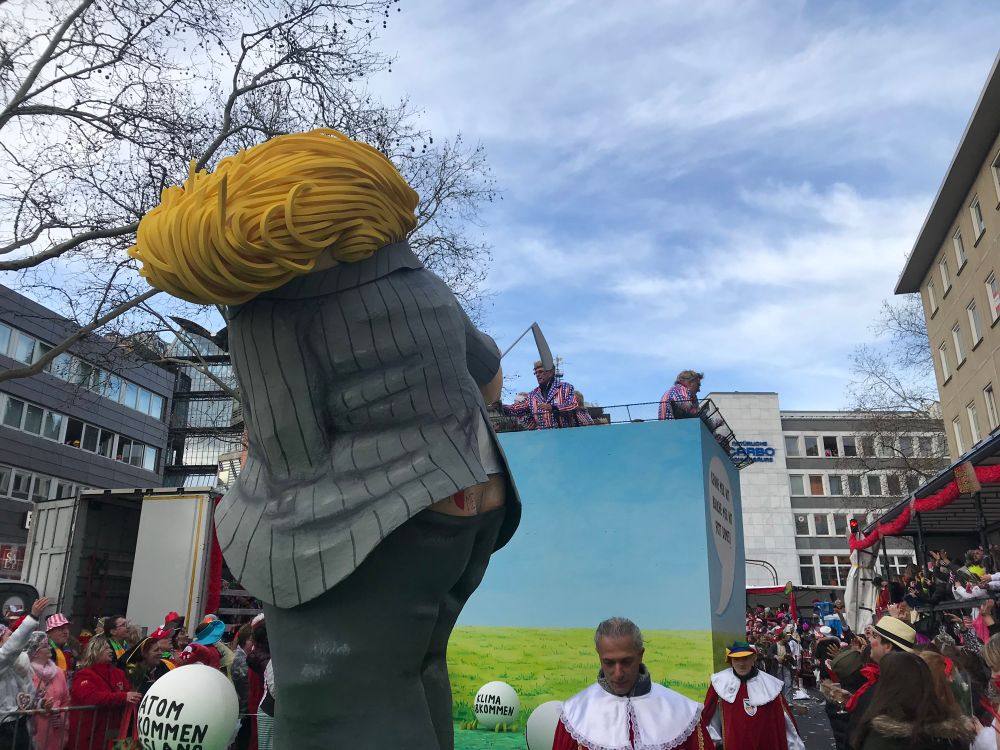 Float in a Kölnisch Karneval Parade of Donald Trump, with his crack showing and a tattoo that says ‘I heart me’ above his left cheek, signature ugly ass yellow hair