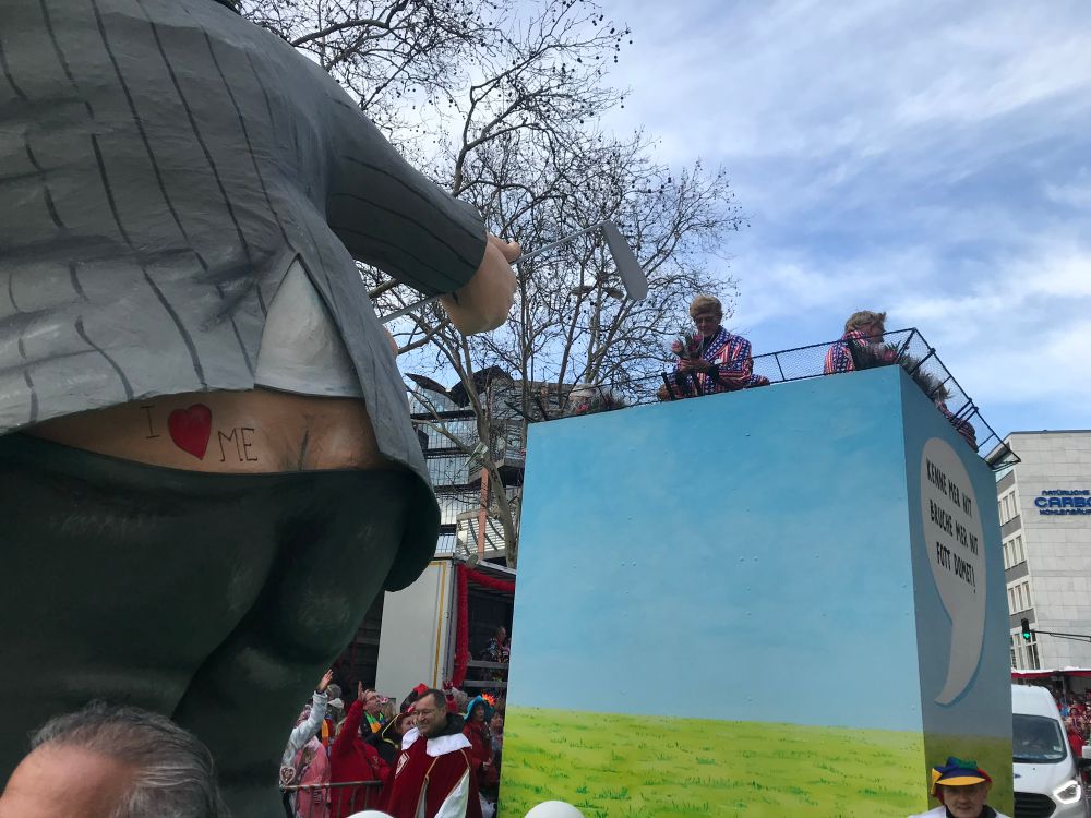 Float in a Kölnisch Karneval Parade of Donald Trump, with his crack showing and a tattoo that says ‘I heart me’ above his left cheek