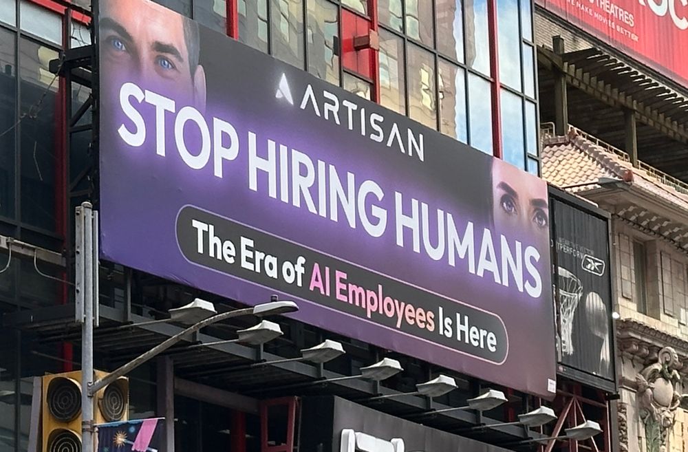 A billboard reading “Stop hiring humans. The era of AI employees is here.”