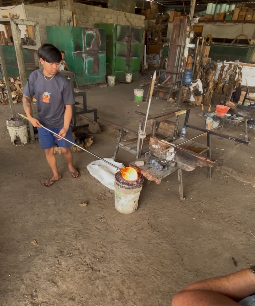 A young man works with molten glass