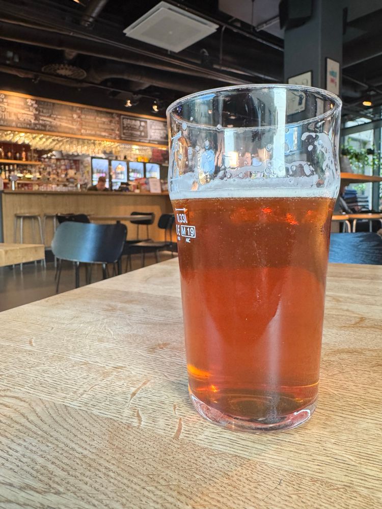 Oluttuoppi pöydällä, taustalla baaritiski.