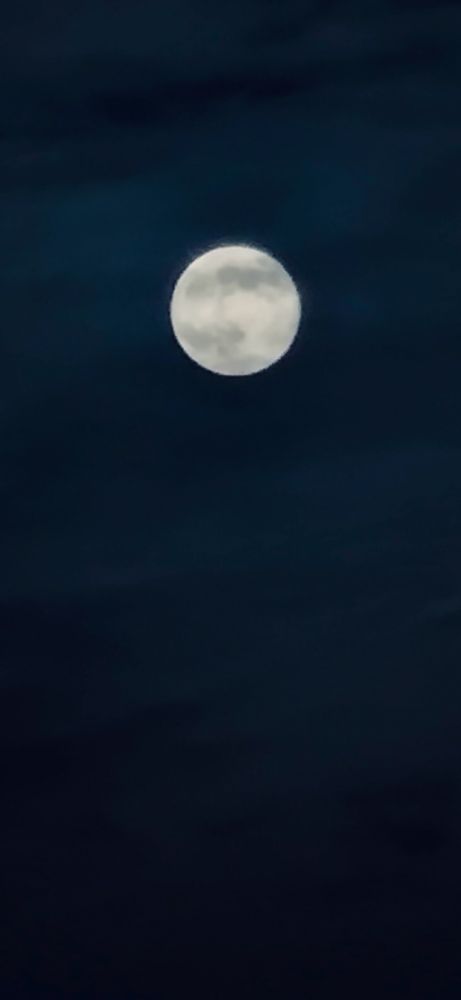 Picture of the Beaver Full Supermoon with some clouds passing it by 