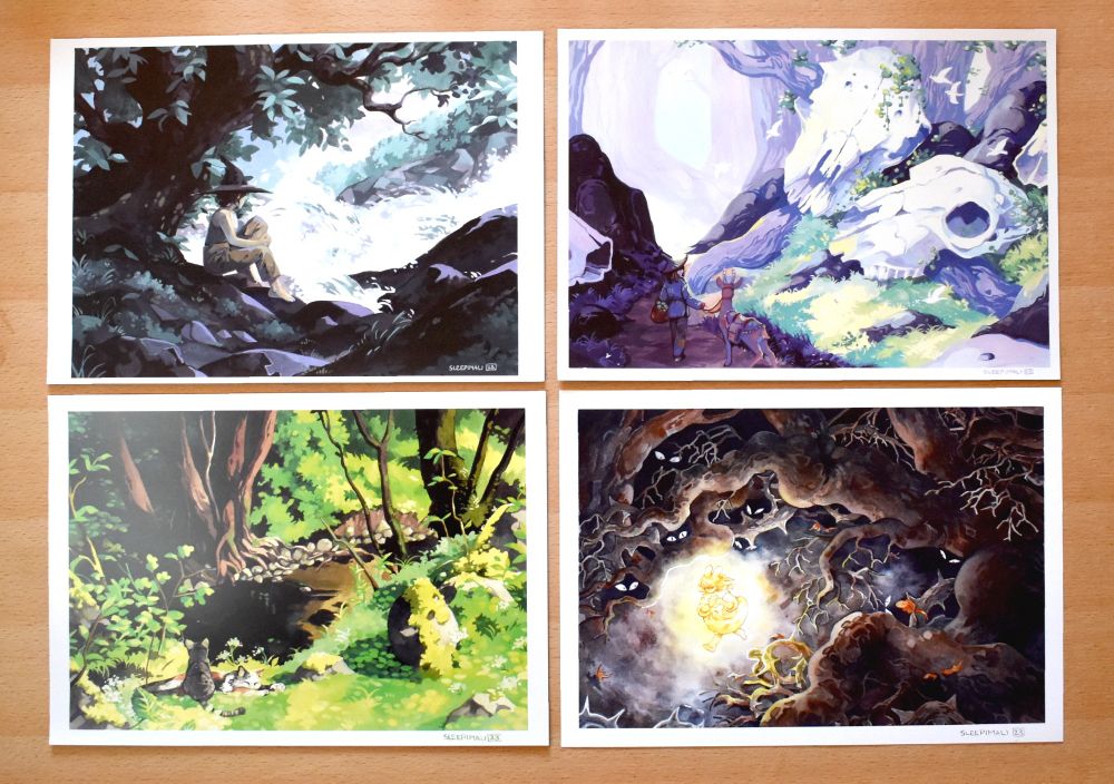 Flatlay of four prints featuring different sceneries and characters (a modern witch sitting by a roaring river, a wanderer and their deer companion in a forest with giant sheep skulls, a couple of cats relaxing by a stream in a sunny forest, and a gloeinh bunny-eared child running through dark woods where watching eyes lurk in the shadows)
