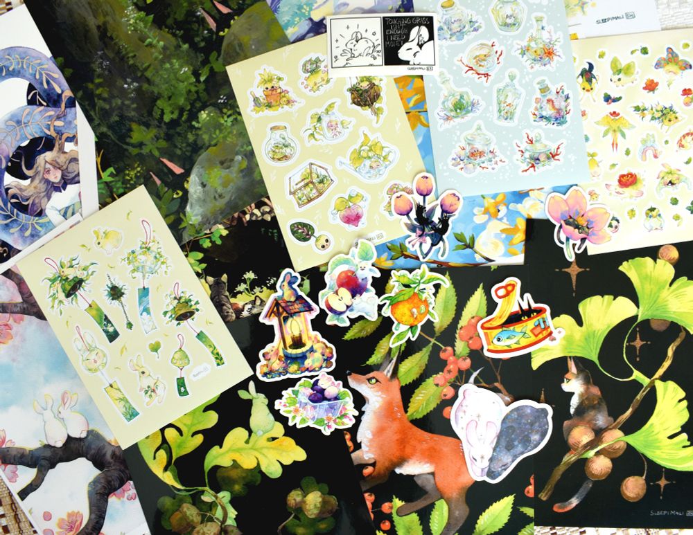 Chaotic flatlay of a bunch of stickers and prints, mostly featuring cute animals