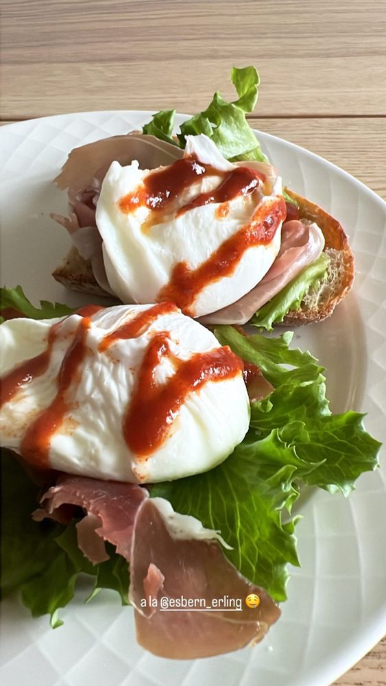 Mynd af réttinum hans Erlings. 2 sneiðar af nýbökuðu súrdeigsbrauði með káli, skinku og hleyptu eggi á hvorri sneið. Ofan á eggjunum er zik-zak af habanero salsa. Myndin er tekin úr Instagram story og á henni stendur "a la @esbern_erling 🤤"