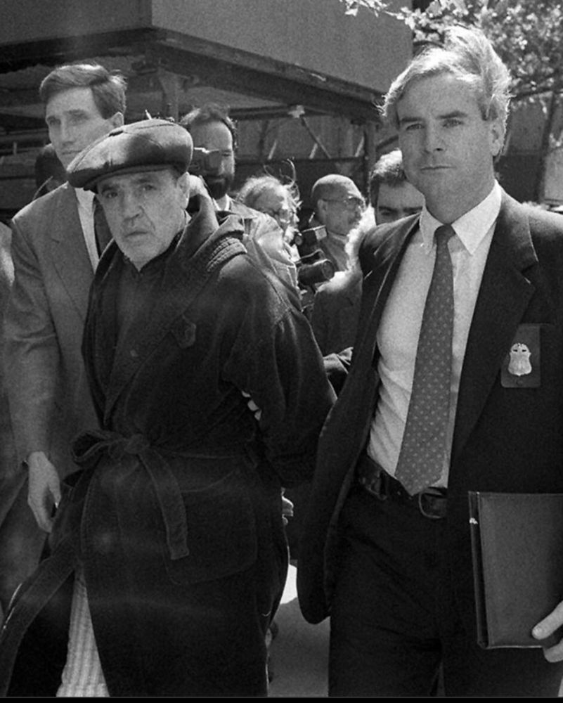 Vincent Giagante wearing his infamous bathrobe, handcuffed and escorted by FBI agents.